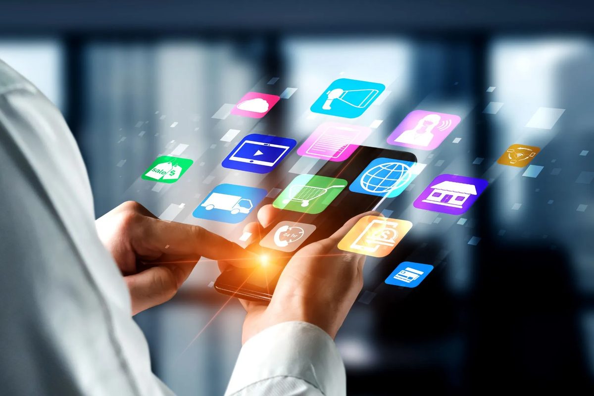 Hand holding a smartphone with floating app icons